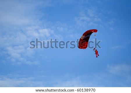 Red parachute on clear blue sky