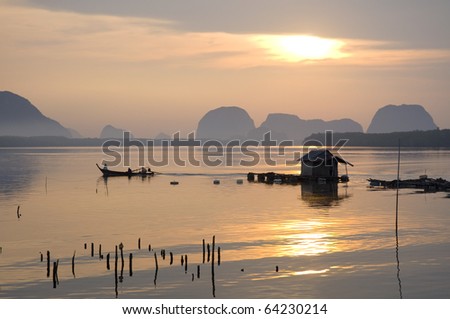 Floating house on ocean off the coast of Andaman sea with dramatic sunrise in the background