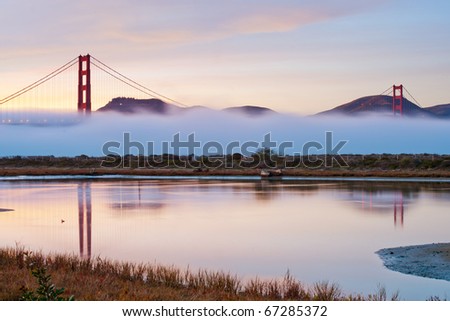 Silhouette photo of Golden Gate bridge emerge from the fog with beautiful sunset