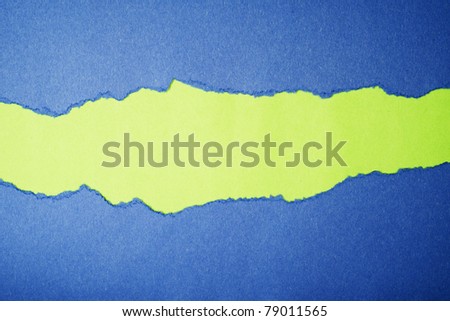 Torn blue color paper on green color paper background with space for text