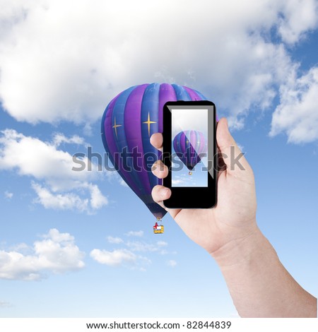 Cell phone in hand take photo of beautiful balloon and sky view