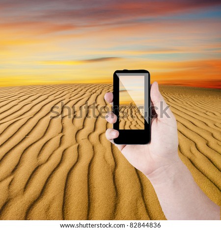 Cell phone in hand take photo of beautiful desert view