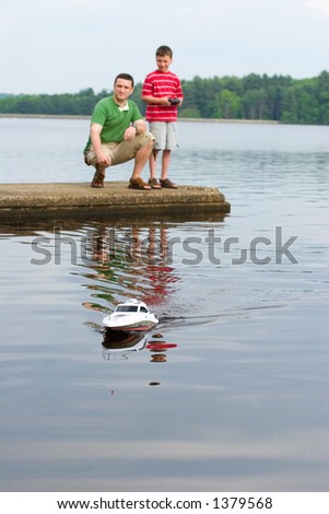 Father and son playing with a remote controlled boat