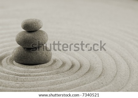 Three stones on raked sand