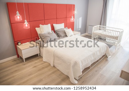 Interior of the room in light colors. Bedroom with a bed and a cot in colors of the year 2019 living coral