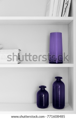 black and white photo of home interior design. closet shelves with vases and books closeup in colors of the year 2018 ultra violet