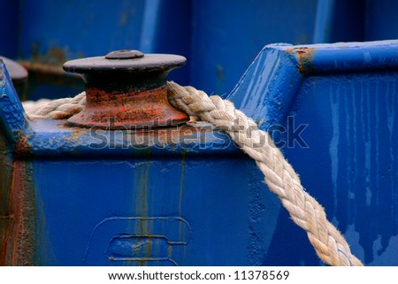 Close-up of a boat anchor rope and rusted pulley