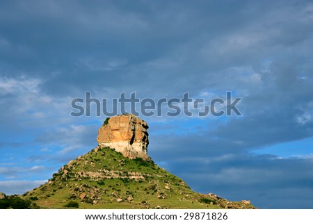 Sandstone buttress against a dark blue sky with thunder clouds, South Africa