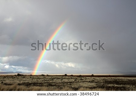 Rural landscape with a colorful rainbow and heavy rain clouds, southern Africa