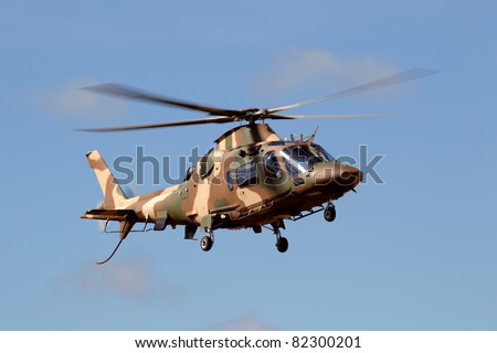 A camouflaged military helicopter in flight