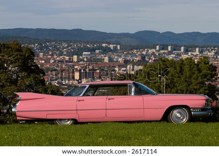 stock photo Pink Cadillac cityscape