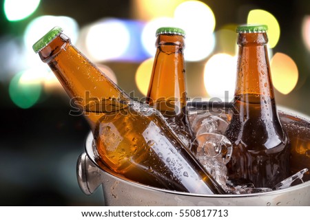 cold bottles of beer in bucket with ice in a restaurant setting