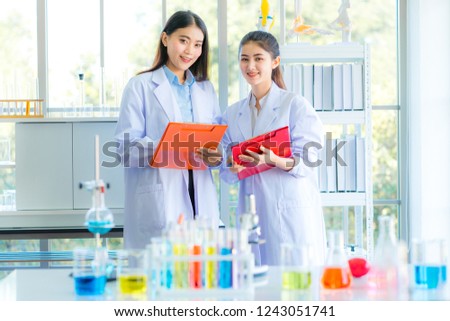 A beautiful asian scientist doctor colleague discussing the chemistry and biotechnology research report at college laboratory. Portrait student doctor, science, biology, chemistry in lab concept.