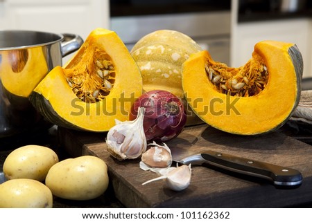 Ingredients for pumpkin soup on a kitchen bench.