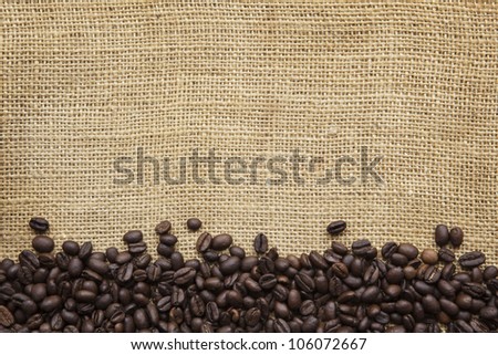 Border of coffee beans over burlap sack background.  Lots of copy space.