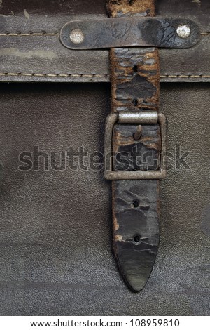 Old buckle and leather strap on vintage suitcase.