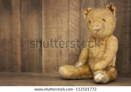 Vintage teddy bear on bookshelf, with grunge effects.