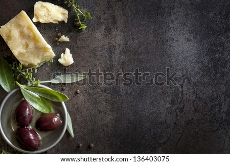 Food Background With Parmesan Cheese, Fresh Herbs And Olives, Over Dark Slate. Lots Of Copy Space.