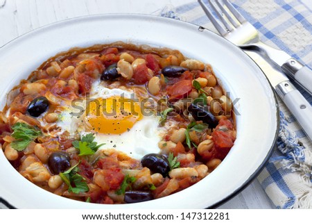 Breakfast beans with egg.  Cannellini beans, tomatoes, black olives, onion and parsley.