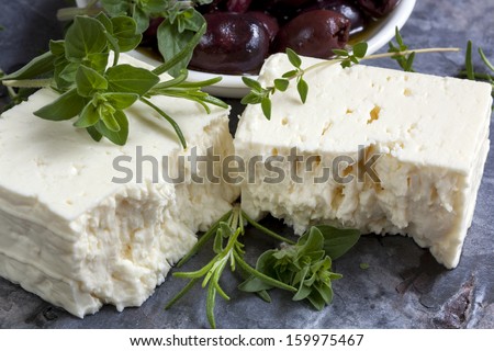 Feta cheese with black olives and fresh herbs.