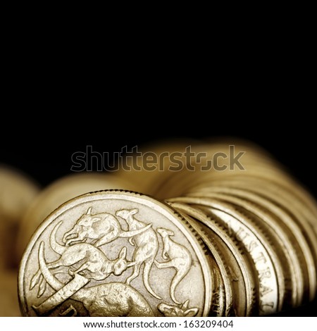 Australian one dollar coins over black background.