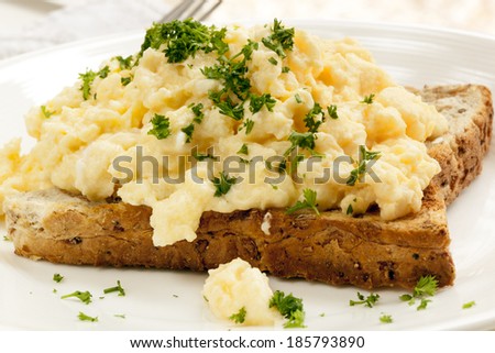 Scrambled eggs on toast, garnished with parsley.