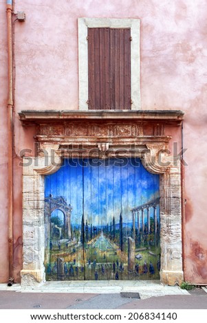 ROUSSILLON, FRANCE - June 17:  Doorway in ancient village of Roussillon, Provence, France, with painting of Roman garden, June 17, 2014.  Roussillon is renowned for its red ochre.