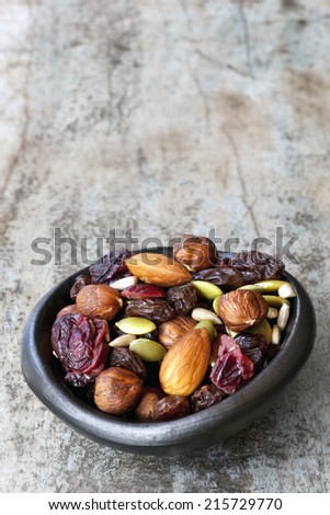 Trail mix in black bowl.  Delicious healthy fruit, nuts and seeds.