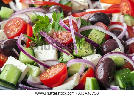 Greek salad in full frame.  Black olives, feta cheese, cucumber, cherry tomatoes, red onions and herbs.