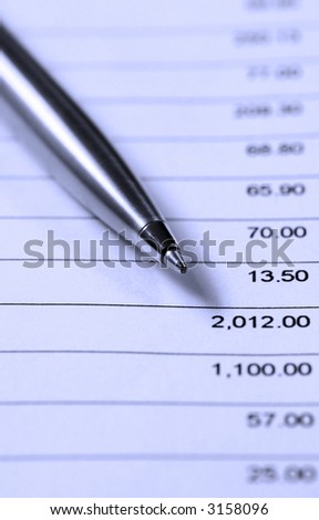 A pen, resting on a sheet of financial figures.  Blue duotone.