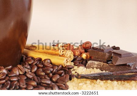 Coffee flavors with room for copy.  Coffee beans, raw sugar, vanilla beans, chocolate chunks, hazelnuts, cinnamon sticks.