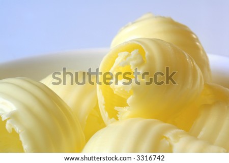 Butter curls in a small white butter dish.