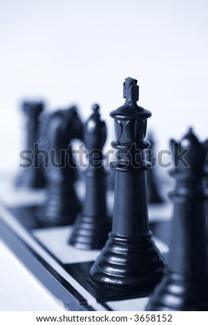 Chess, with focus on the king.  Very shallow depth of field.  Blue duotone.