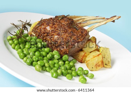 Rack of lamb with fresh-shelled peas and roasted potatoes.  The lamb is cooked with seeded mustard and rosemary.