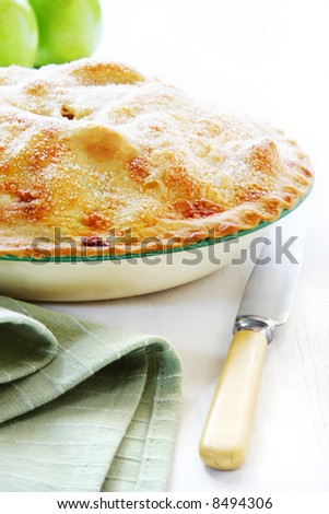 Home-baked apple pie, straight from the oven.  Vintage enamel pie plate and bone-handled knife.