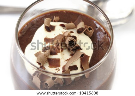 Chocolate mousse topped with whipped cream and shaved chocolate curls.  A delicious sweet dessert.