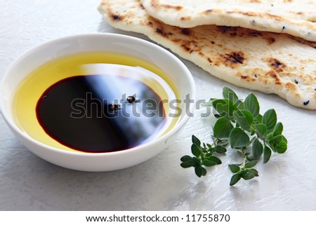 Oil and vinegar - small bowl of olive oil and balsamic vinegar, with dipping bread and fresh herbs.