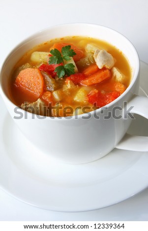 Home-made chicken and vegetable soup, in a white soup cup.