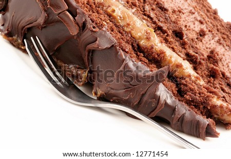 Slice of chocolate mud cake, with cake fork.  Close-up view.  Delicious unhealthy eating!