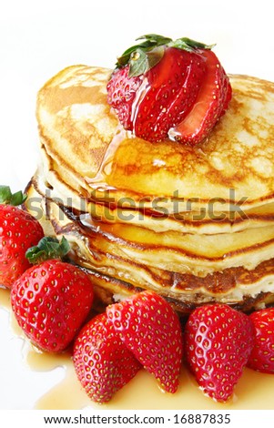 Stack of pancakes with fresh strawberries and maple syrup.  Close-up view of this indulgent meal.