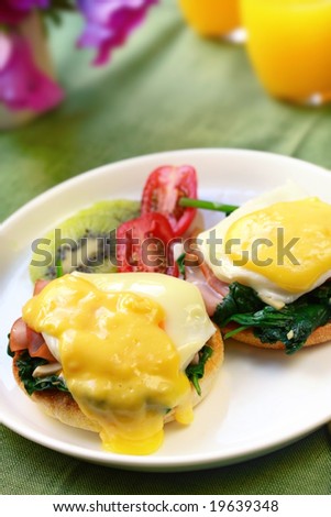 Eggs benedict.  Poached eggs on toasted muffins, with spinach, ham and hollandaise sauce.  Accompanied by fresh fruit and juice.  An indulgent breakfast!
