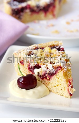 Serving of cherry and almond pie or tart, with fresh whipped cream.