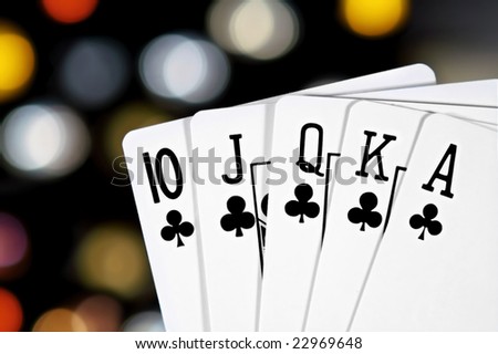 A royal flush, club suit, with colorful bokeh in the background.