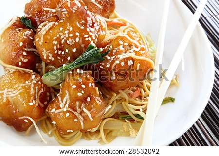 Honey chicken with noodles and vegetables, topped with sesame seeds.