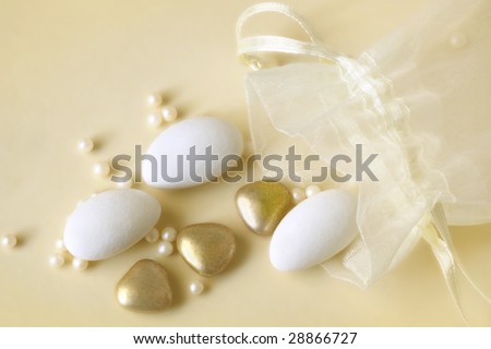 Wedding favor bag, spilling sugar-coated almonds and gold heart-shapes.  Traditional Italian or Greek gift to wedding guests.