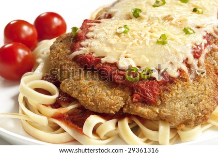 Chicken parmesan or parmigiana, with melting mozzarella and parmesan cheeses, over fettucine ribbon pasta.