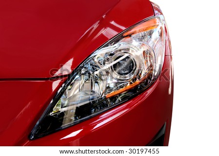 Headlight of modern red car, isolated on white.