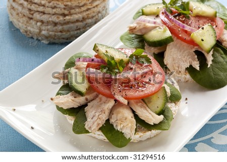 Rice crackers with white flaked tuna, baby spinach, tomato, cucumber and red onion.  Healthy eating!