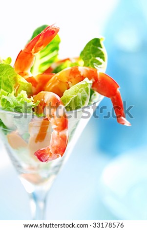 Shrimp cocktail in a martini glass, with cos lettuce and seafood cocktail sauce.