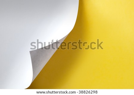 White paper curling, over vibrant yellow paper background, with natural shadow.
